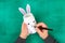 DIY Easter vase bunny from glass jar, felt, googly eyes on a green background