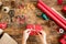 DIY Gift Wrapping. Woman wrapping beautiful red christmas gifts on rustic wooden table. Overhead point of view.