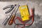 DIY home electricity working tools, screwdrivers, pliers and multimeter on cement background