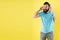 DJ, let music play. DJ man yellow background. Bearded man listen to music in DJ headphones. Hipster use wireless