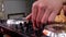 DJ mixes songs on equipment, hands closeup