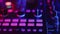 DJ's hand adjusts frequency effect to mid level in neon light in nightclub, closeup. Concept of professional musical