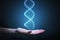 DNA and genetics research concept. Hand is holding glowing DNA molecule in hand