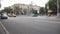 DNIPRO, UKRAINE - July 3, 2019: Cars rush along the road. Crossroads near a public transport stop. People walk on the sidewalks or