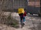 Dnipro, Ukraine - March 27, 2020: GLOVO delivery woman courier on bike with branded yellow thermal backpacks deliver customer