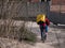 Dnipro, Ukraine - March 27, 2020: GLOVO delivery woman courier on bike with branded yellow thermal backpacks deliver customer