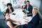 We do business better. Portrait of a group of businesspeople sitting together in an office.