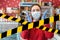 Do not cross.Barrier tape-quarantine,isolation.A woman in rubber gloves and a medical mask raises her hands in stress.In the