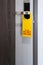 Do not disturb room label tag hotel sign hanging on modern metal doorknob handle on wooden door with workspace for your own