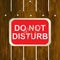 DO NOT DISTURB sign hanging on a wooden fence