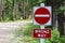 A do not enter, wrong way sign beside a gravel road