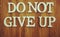 Do Not Give Up word made from wooden cubes with letters alphabet on wooden background