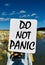 Do not panic text written on white board with nature background. Stock photo.