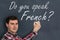 Do you speak French? Man with chalk writing on blackboard