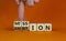 Do your mission with ambition. Businessman turns wooden cubes and changes the word mission to ambition. Beautiful orange table,