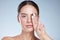 Do yourself a favour. Studio portrait of an attractive young woman moisturizing her face against a grey background.