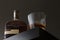 A doable oak finished bottle of bourbon whiskey sits on a shelf next to a rocks drinking glass