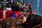 A Doberman puppy lies on a fur rug against the background of a Christmas tree, gifts and a decorative fireplace. Copy space