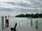 Dock with a bench overlooking water on a cloudy day.