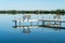 A dock with inviting benches is reflected in a very calm lake in Minnesota