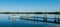 A dock with inviting benches is reflected in a very calm lake in Minnesota