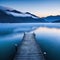 dock on lake with mountains in the background at dusk with fog on the water