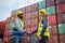 Dock manager and engineer worker shake hand with smile in shipping container yard. Import and export product. Manufacturing