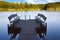 Dock or pier on lake in summer day. Empty footbridge with two benches in Belarus