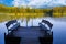 Dock or pier on lake in summer day. Empty footbridge with two benches in Belarus
