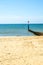 Dock pilings on a sandy beach, blue ocean and yellow sand, sunny