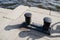 On the dock at the port. old cast iron mooring bollards on the granite