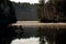 A dock reflects in calm lake water in a misty sunrise in Western