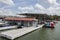 Dock and store gas station at luxury marina that has private patios for boat stalls - American flags flying and restaurant in