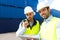 Dock worker and supervisor checking containers data on tablet