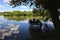 Docked boat under a tree in the shade by a river in the italian countryside