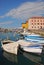 Docked small wooden motor boats lined along the waterfront of Seaside town Piran