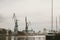 Docks on the Martwa Wisla in Poland city of GdaÅ„sk with docked cargo ship under repair and port cranes in background during