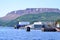 Docks and shipping containers along Bonne Bay with The Tablelands on the horizon