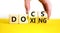 Docs or doxing symbol. Concept words Docs Doxing on wooden block. Beautiful yellow table white background. Businessman hand.