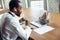 Doctor advising the patient online with laptop. African-american doctor during his videocall, work with patients