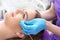 The doctor of aesthetic medicine performs a facial skin scraping treatment with a syringe.