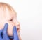 Doctor allergist examines a red pimple on the face of a little girl`s child for the presence of an allergy to sweets, copy space,