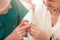 Doctor applying hearing aid to senior woman`s ear