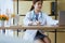 Doctor asian woman sitting and working on desk using labtop and writing note at hospital