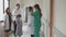 Doctor and assistant or nurse walking on corridor and greeting family of patient and discussion together.