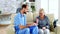 Doctor assistant taking notes on clipboard while listening to old retired woman in nursing home