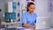 Doctor assistant in uniform working on laptop in modern hospital