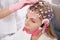 Doctor attaches cap with electrodes womans head for diagnostic procedure