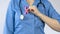 Doctor attaching pink ribbon uniform, breast anticancer campaign, women disease