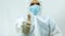 Doctor in bioprotective suit and blue mask standing with his arm extended and his hand with thumb up making LIKE sign in the